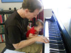 Composer with 3-month old son at the piano.